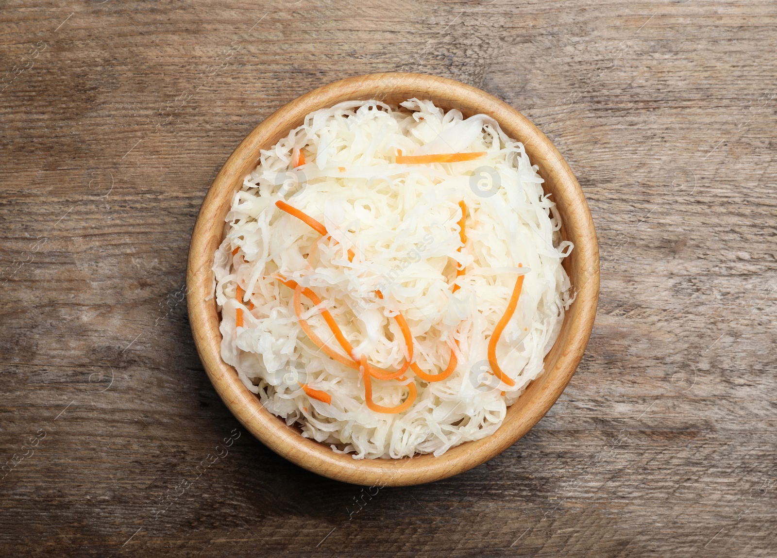 Tasty fermented cabbage on wooden table, top view Photo of Tasty fermented cabbage on wooden table, top view