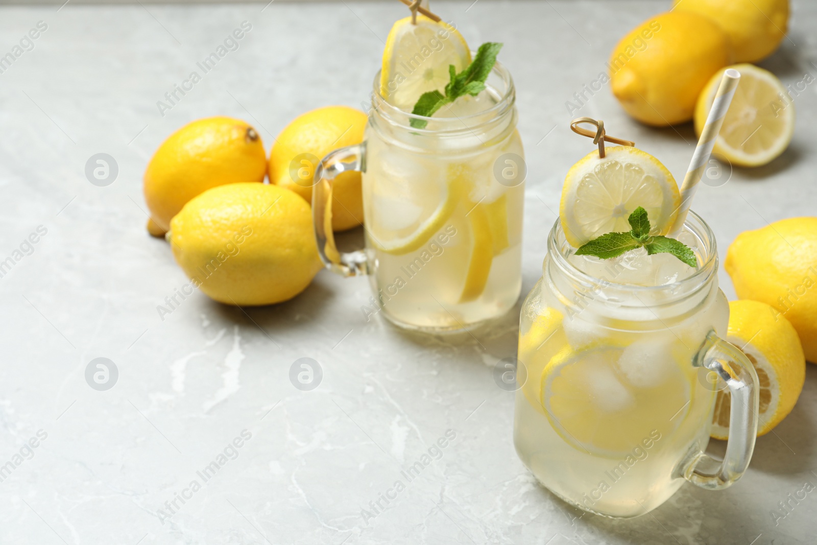 Natural lemonade with mint and fresh fruits on light grey marble table. Summer refreshing drink Photo of Natural lemonade with mint and fresh fruits on light grey marble table. Summer refreshing drink