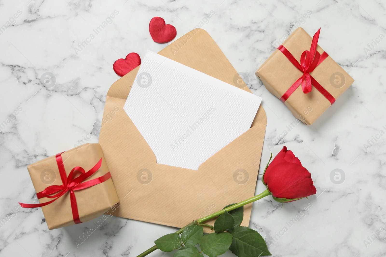 Flat lay composition with blank greeting card, rose and gifts on white marble table. Valentine's day celebration Photo of Flat lay composition with blank greeting card, rose and gifts on white marble table. Valentine's day celebration