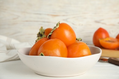 Delicious fresh persimmons on white table, closeup Photo of Delicious fresh persimmons on white table, closeup