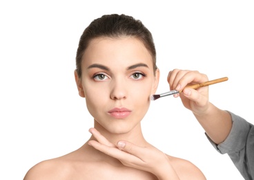 Visage artist applying makeup on woman's face against white background. Professional cosmetic products Photo of Visage artist applying makeup on woman's face against white background. Professional cosmetic products