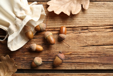 Acorns and oak leaves on wooden table, flat lay. Space for text Photo of Acorns and oak leaves on wooden table, flat lay. Space for text
