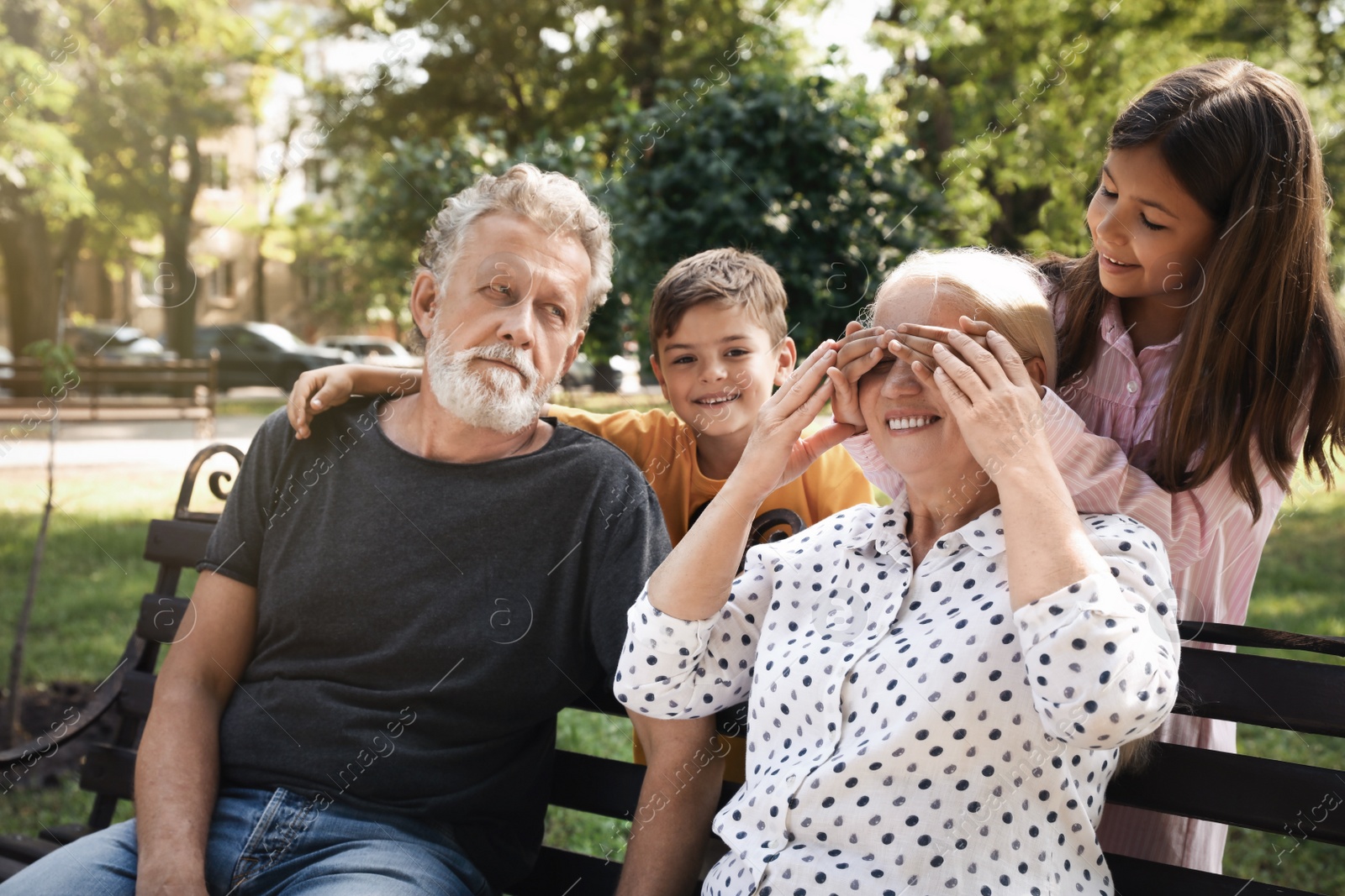 Happy grandparents with little children having fun together in park Photo of Happy grandparents with little children having fun together in park