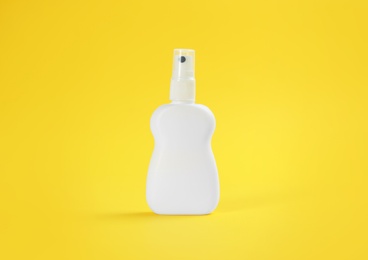 Bottle with insect repellent spray on yellow background Photo of Bottle with insect repellent spray on yellow background
