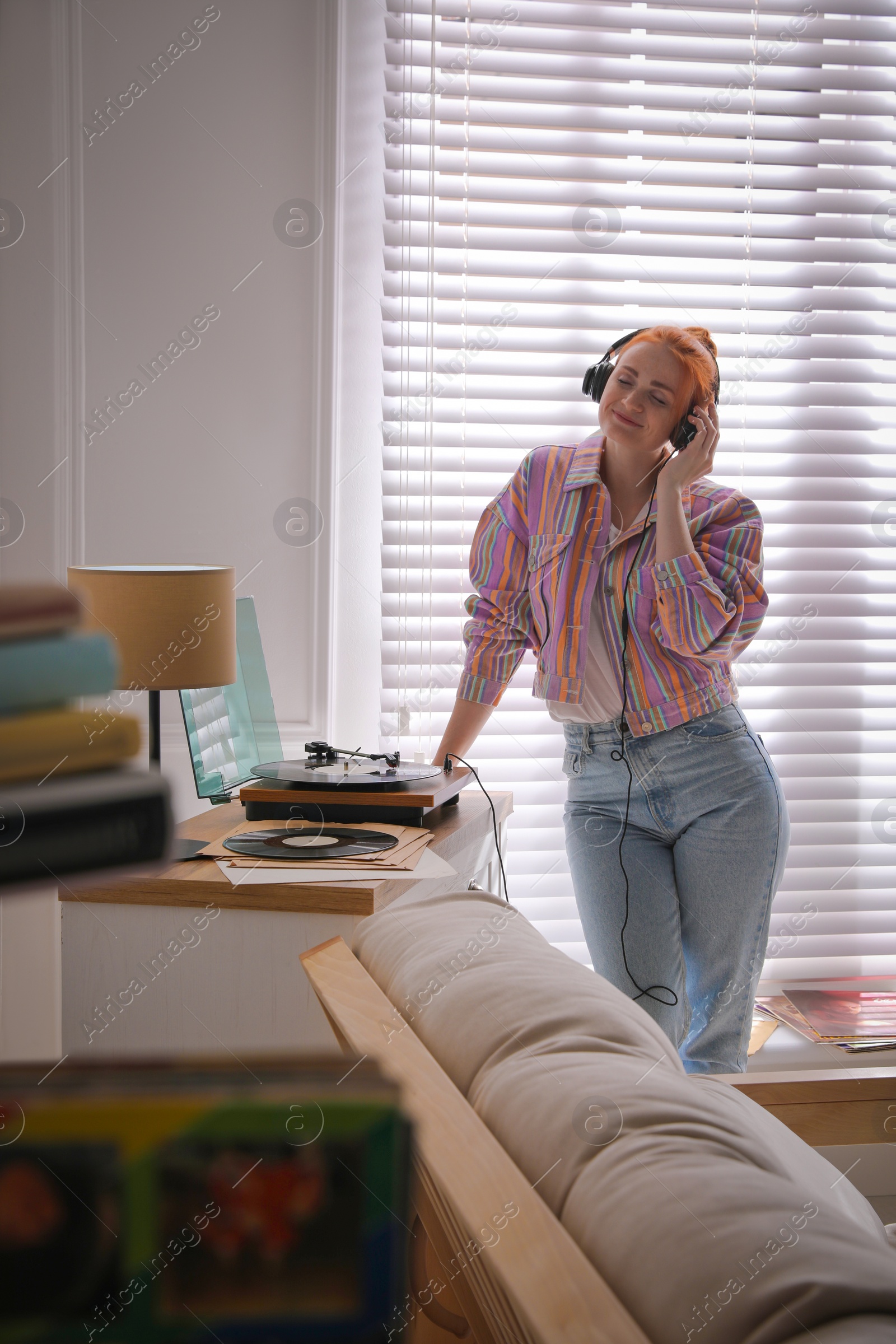 Young woman listening to music with turntable at home Photo of Young woman listening to music with turntable at home