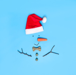 Creative snowman shape made of Santa hat and different items on light blue background, flat lay Photo of Creative snowman shape made of Santa hat and different items on light blue background, flat lay