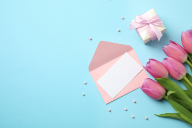 Flat lay composition with tulips and card on light blue background, space for text. Happy Mother's day Photo of Flat lay composition with tulips and card on light blue background, space for text. Happy Mother's day