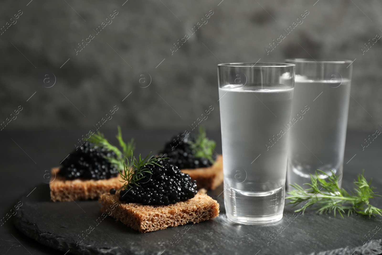 Cold Russian vodka and sandwiches with black caviar on table, closeup Photo of Cold Russian vodka and sandwiches with black caviar on table, closeup