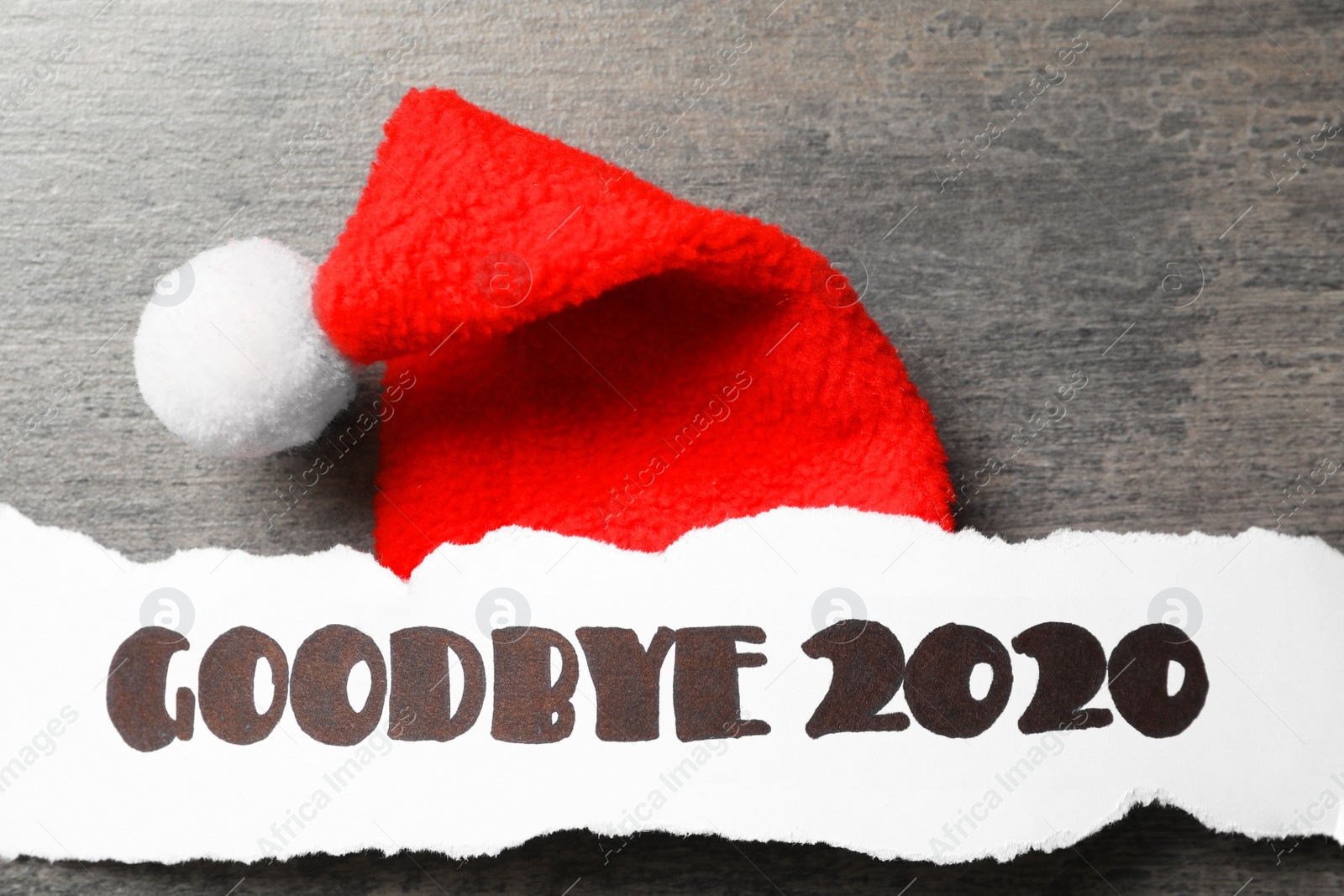 Paper sheet with text Goodbye 2020 and Santa hat on grey background, flat lay Photo of Paper sheet with text Goodbye 2020 and Santa hat on grey background, flat lay