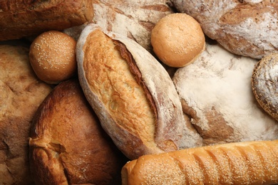 Different kinds of delicious bread as background, top view Photo of Different kinds of delicious bread as background, top view