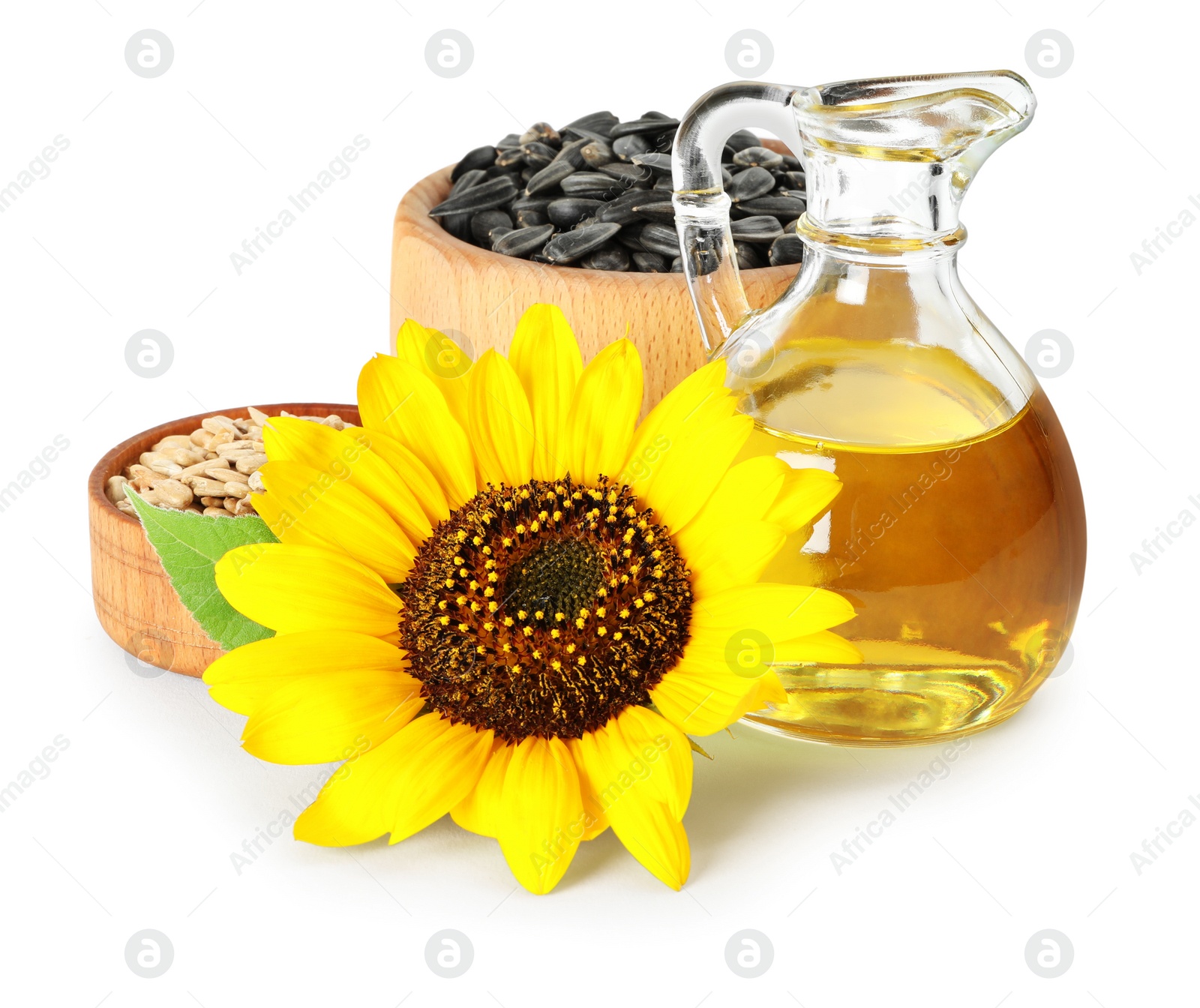 Photo of Sunflower, jug of oil and seeds on white background