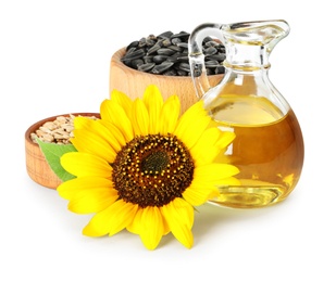Photo of Sunflower, jug of oil and seeds on white background