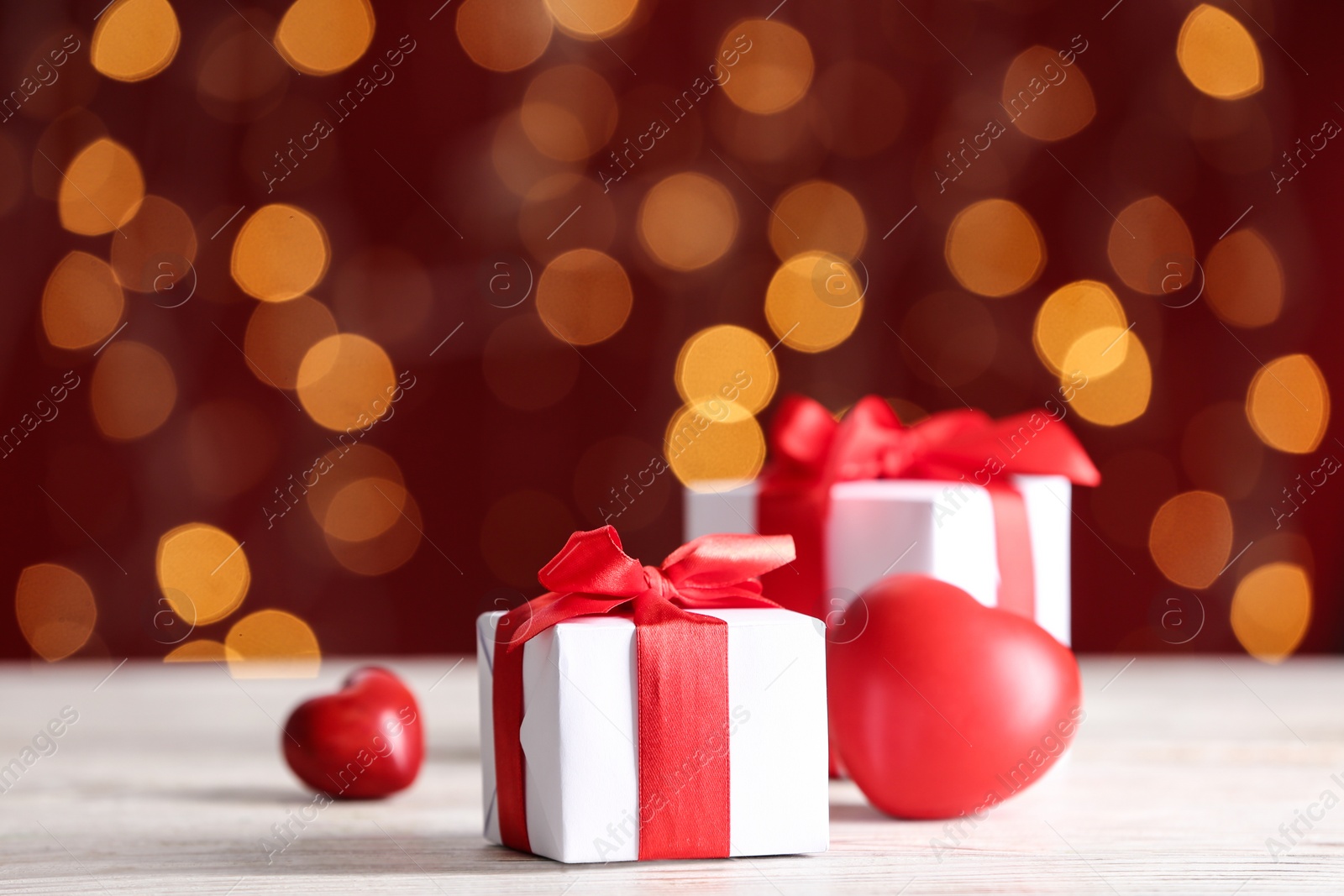 Gift boxes and decorative hearts on light wooden table, space for text. Valentine's Day celebration Photo of Gift boxes and decorative hearts on light wooden table, space for text. Valentine's Day celebration