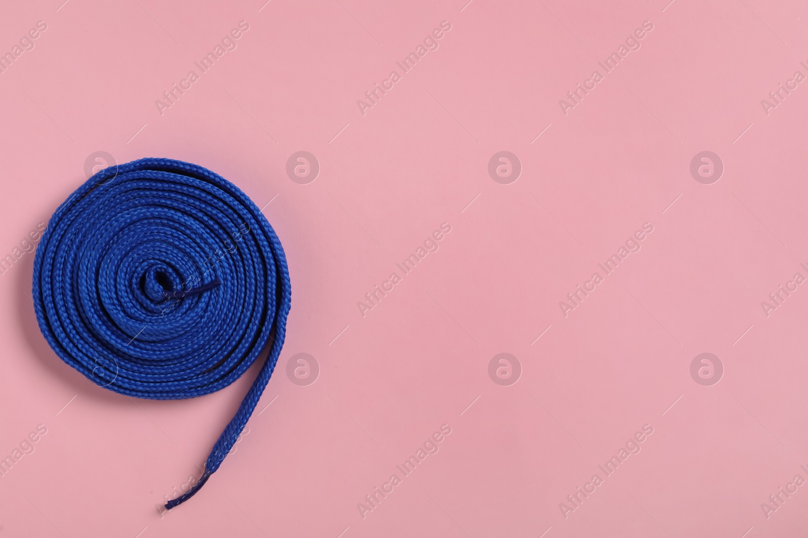 Blue shoelace on pink background, top view. Space for text Photo of Blue shoelace on pink background, top view. Space for text
