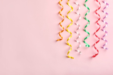 Colorful serpentine streamers on pink background, flat lay. Space for text Photo of Colorful serpentine streamers on pink background, flat lay. Space for text