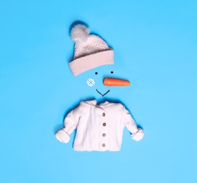 Creative snowman shape made of different items on light blue background, flat lay Photo of Creative snowman shape made of different items on light blue background, flat lay