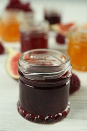 Open glass jar of sweet jam on white wooden table, closeup. Space for text Photo of Open glass jar of sweet jam on white wooden table, closeup. Space for text
