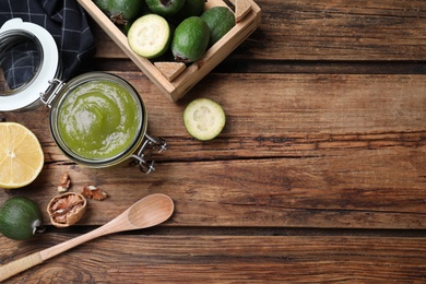 Feijoa jam and fruits on wooden table, flat lay. Space for text Photo of Feijoa jam and fruits on wooden table, flat lay. Space for text