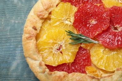 Delicious galette with citrus fruits and rosemary on blue wooden table, top view Photo of Delicious galette with citrus fruits and rosemary on blue wooden table, top view