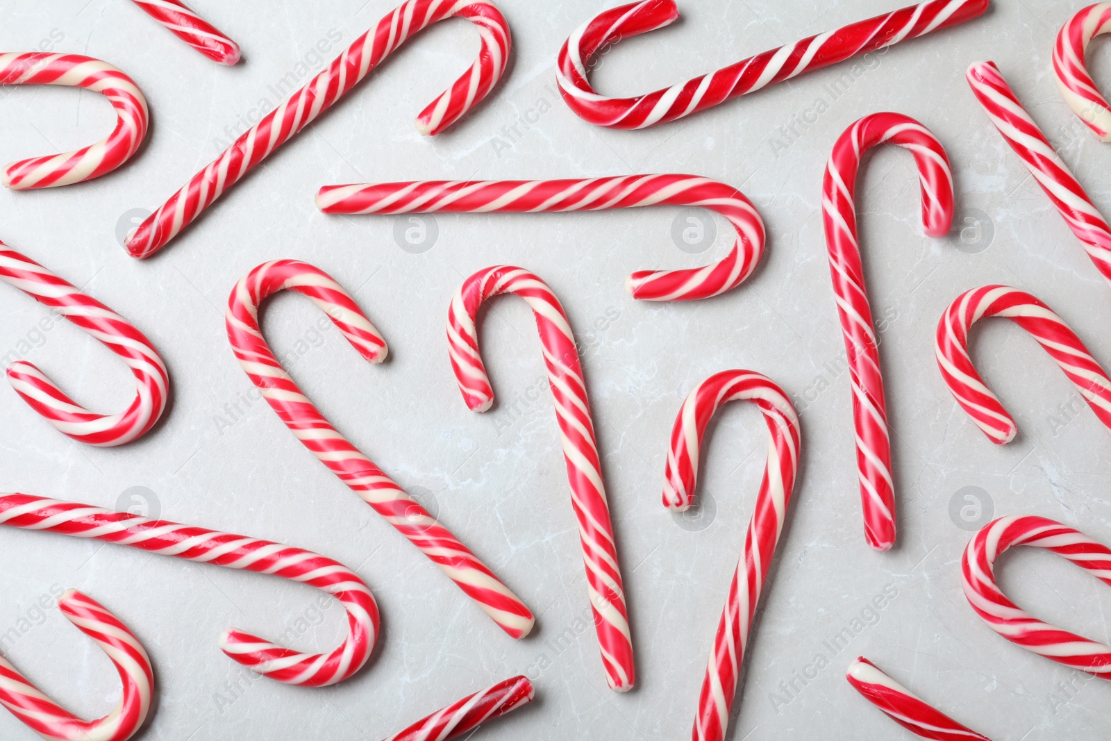 Sweet Christmas candy canes on grey background, flat lay Photo of Sweet Christmas candy canes on grey background, flat lay