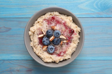 Tasty oatmeal porridge with toppings on light blue wooden table, top view Photo of Tasty oatmeal porridge with toppings on light blue wooden table, top view