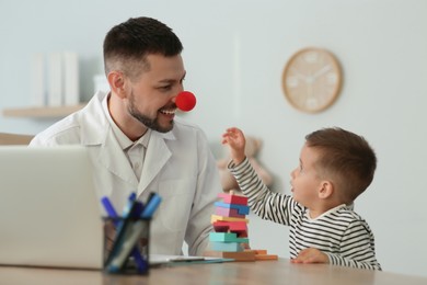 Pediatrician playing with little boy at hospital Photo of Pediatrician playing with little boy at hospital