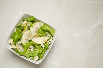 Fresh salad with pear on light table, top view. Space for text Photo of Fresh salad with pear on light table, top view. Space for text