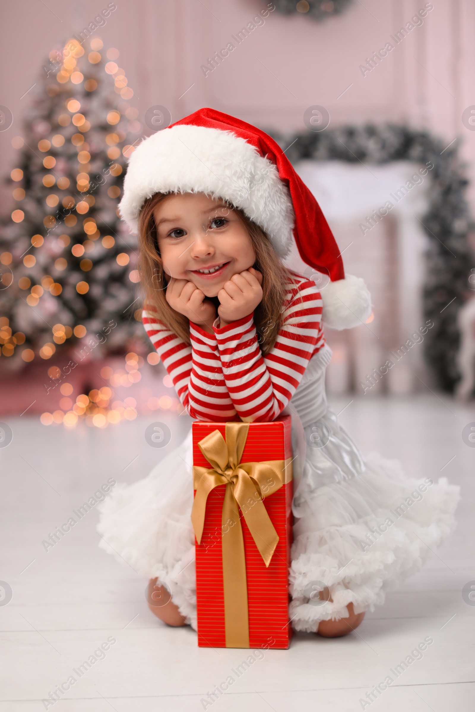 Cute little child with Christmas gift at home Photo of Cute little child with Christmas gift at home