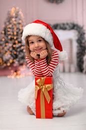 Cute little child with Christmas gift at home Photo of Cute little child with Christmas gift at home