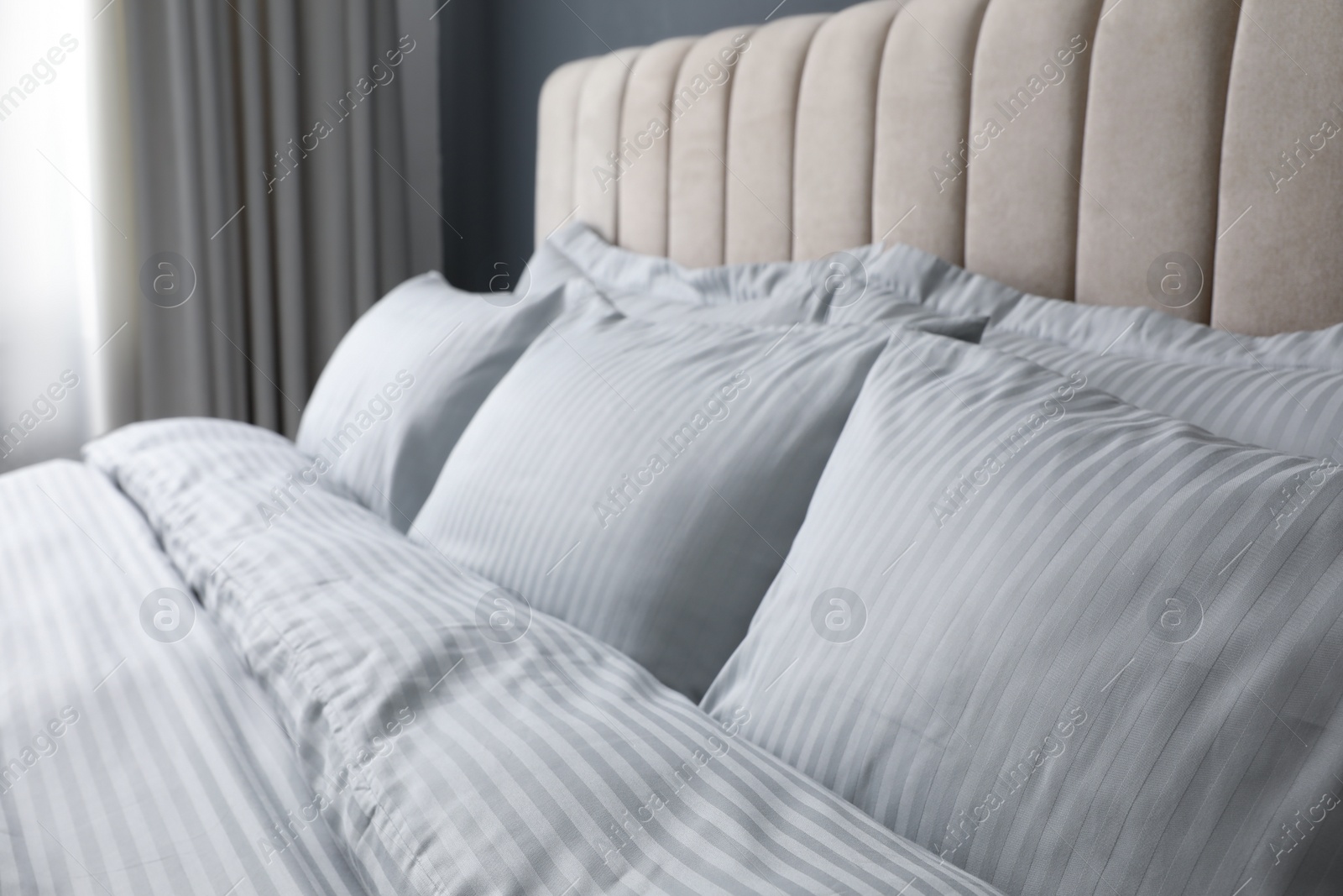 Comfortable bed with soft blanket and pillows indoors, closeup Photo of Comfortable bed with soft blanket and pillows indoors, closeup