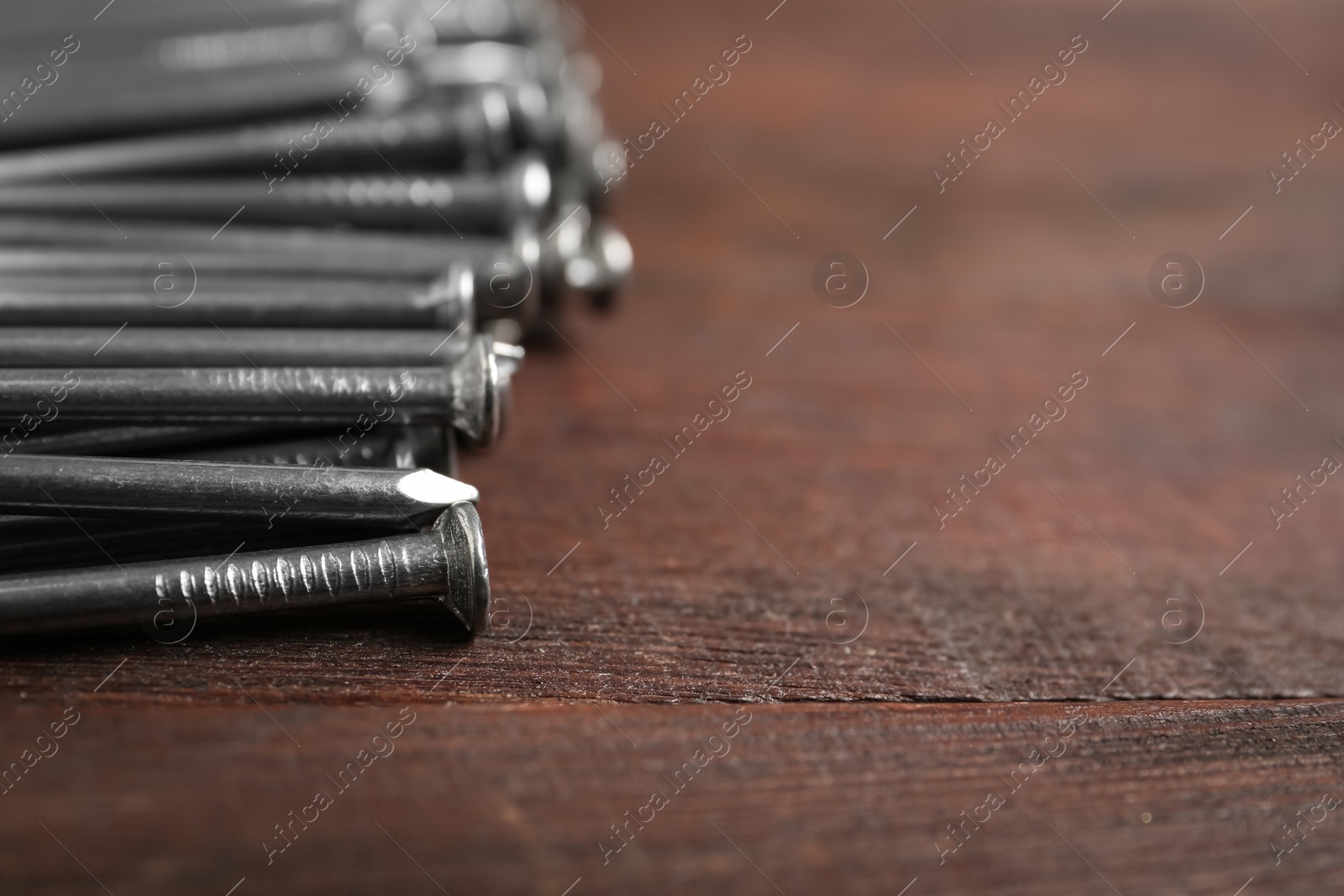 Many metal nails on wooden background, closeup. Space for text Photo of Many metal nails on wooden background, closeup. Space for text