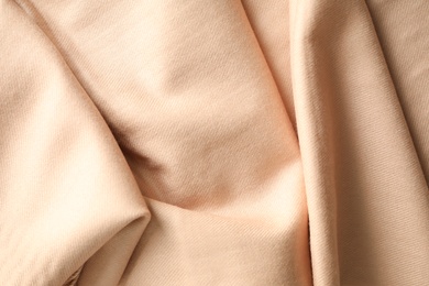 Beige soft cashmere scarf as background, closeup Photo of Beige soft cashmere scarf as background, closeup