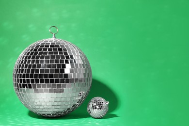 Shiny disco balls on green background. Space for text Photo of Shiny disco balls on green background. Space for text