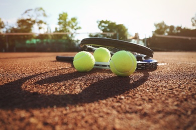 Tennis balls and rackets on clay court Photo of Tennis balls and rackets on clay court