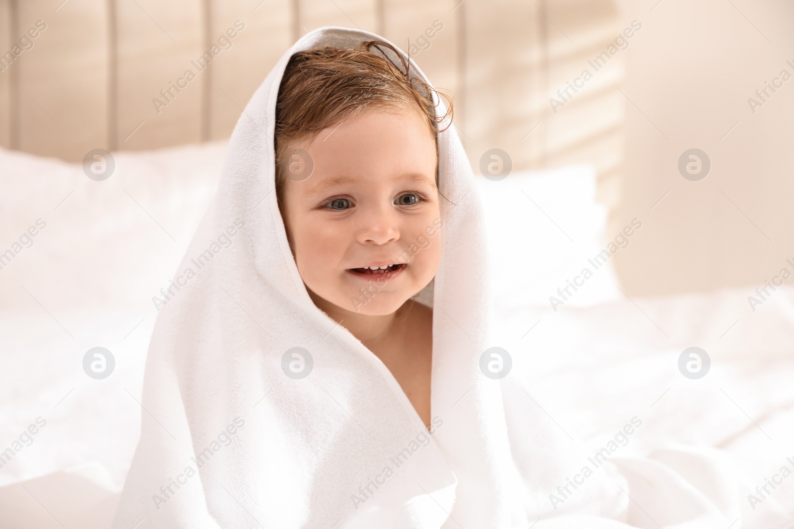 Cute little baby with soft towel on bed after bath Photo of Cute little baby with soft towel on bed after bath