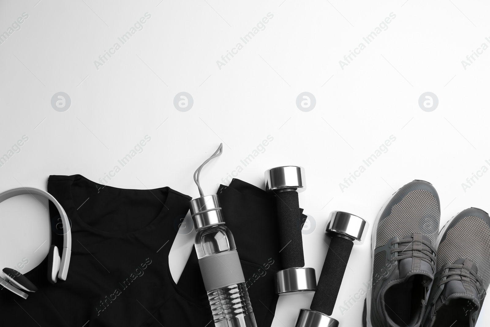 Flat lay composition with sportswear and dumbbells on white background, space for text. Gym workout Photo of Flat lay composition with sportswear and dumbbells on white background, space for text. Gym workout