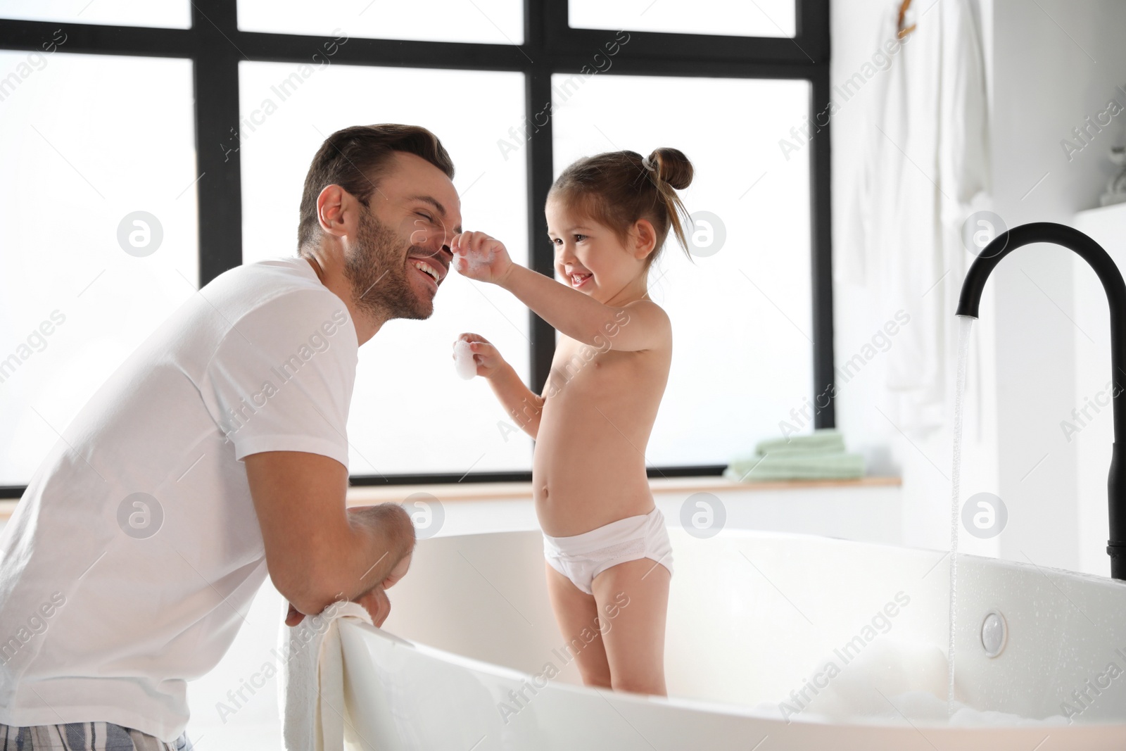 Young father with cute little daughter in bathroom Photo of Young father with cute little daughter in bathroom