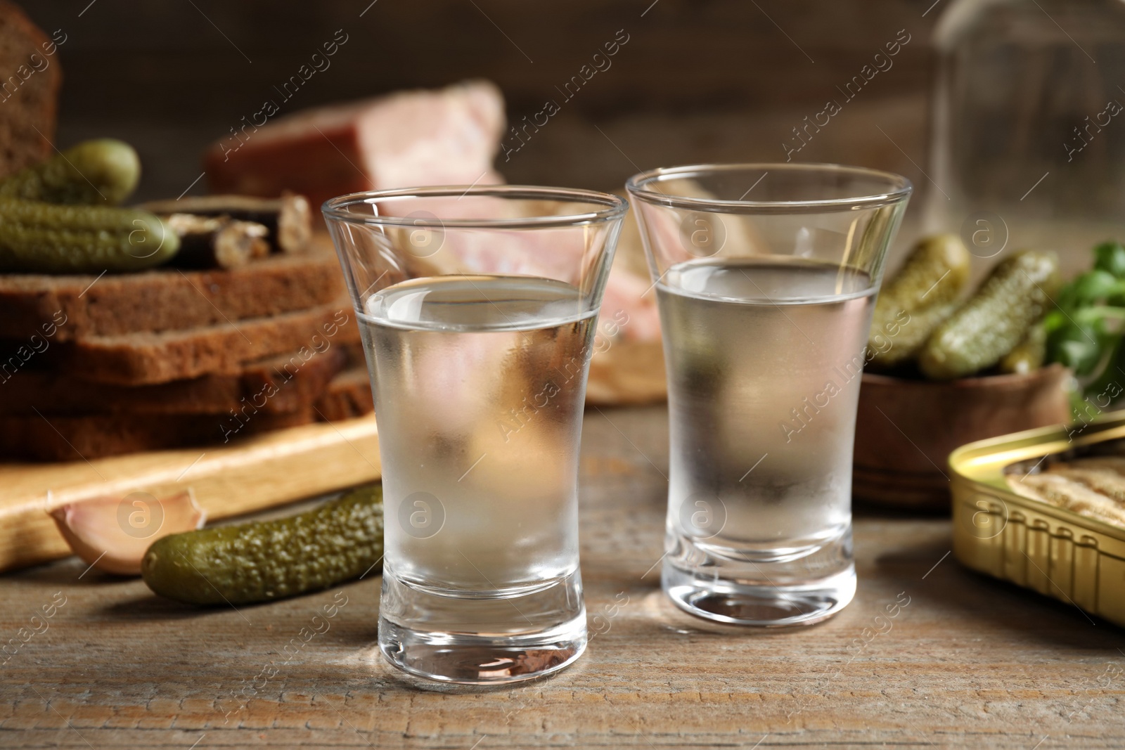 Cold Russian vodka with snacks on wooden table, closeup Photo of Cold Russian vodka with snacks on wooden table, closeup