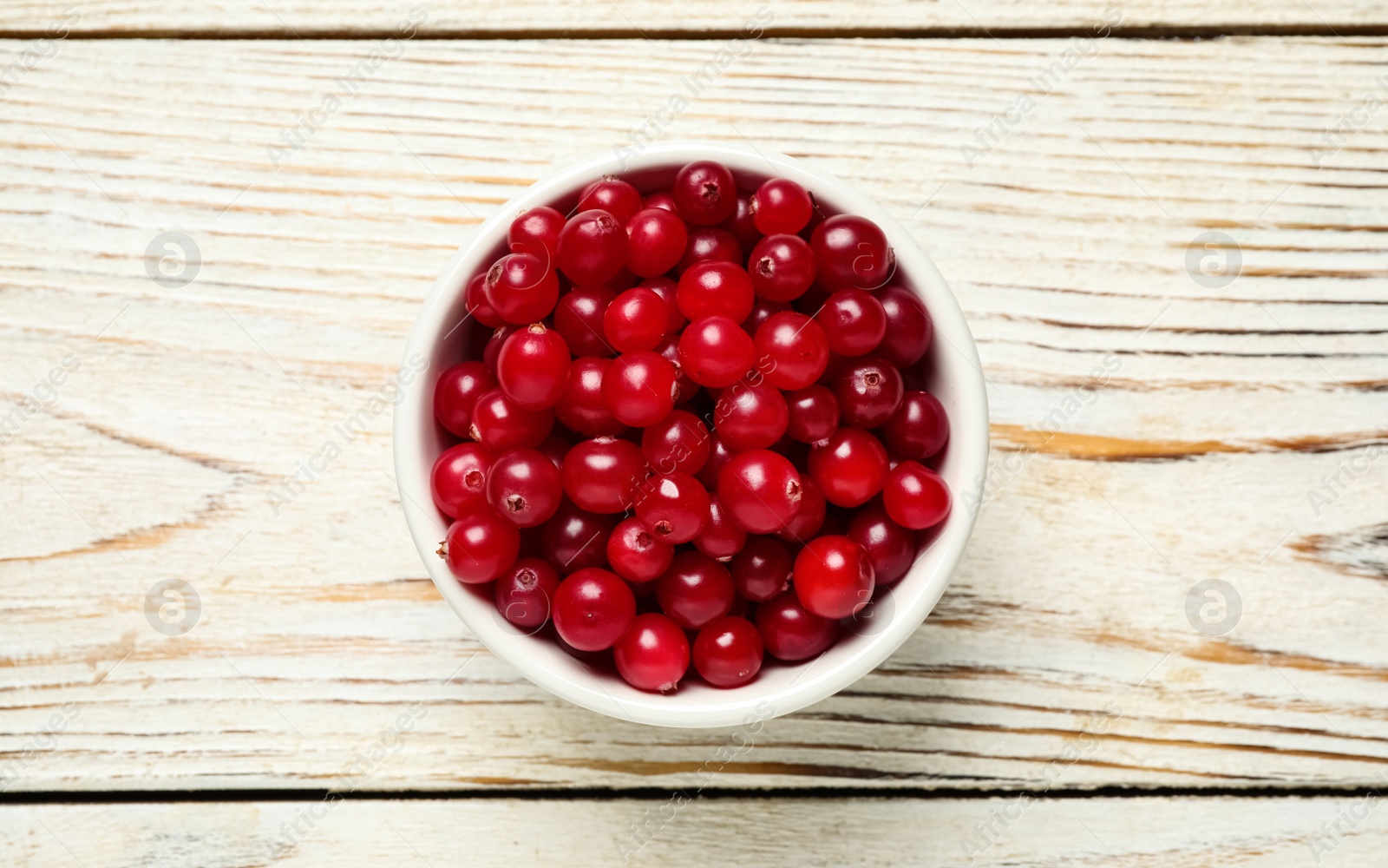 Tasty ripe cranberries on white wooden table, top view Photo of Tasty ripe cranberries on white wooden table, top view