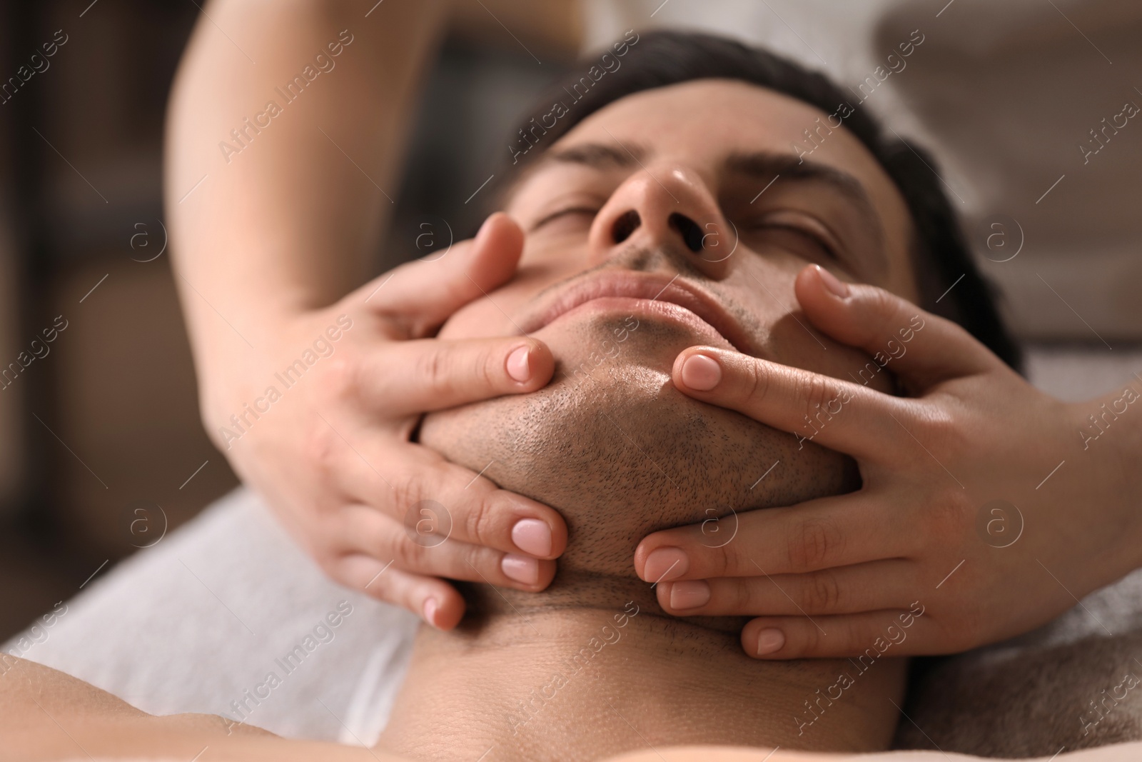 Man receiving facial massage in beauty salon, closeup Photo of Man receiving facial massage in beauty salon, closeup