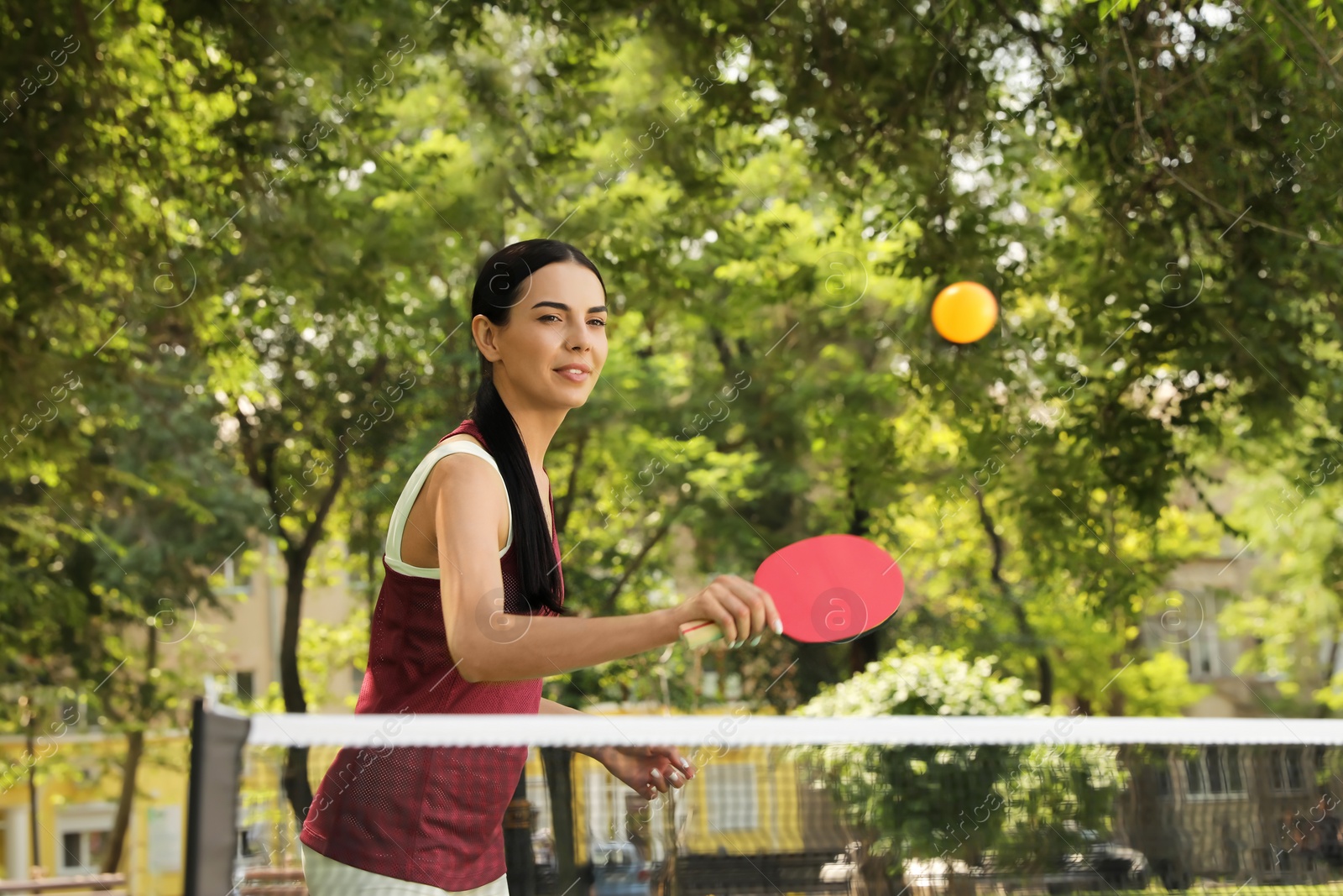 Young woman playing ping pong in park Photo of Young woman playing ping pong in park