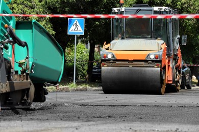 Roller working on city street. Road repairing Photo of Roller working on city street. Road repairing