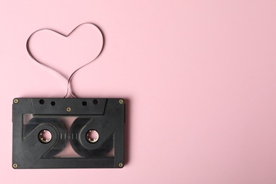 Top view of music cassette and heart made with tape on pink background, space for text. Listening love song Photo of Top view of music cassette and heart made with tape on pink background, space for text. Listening love song