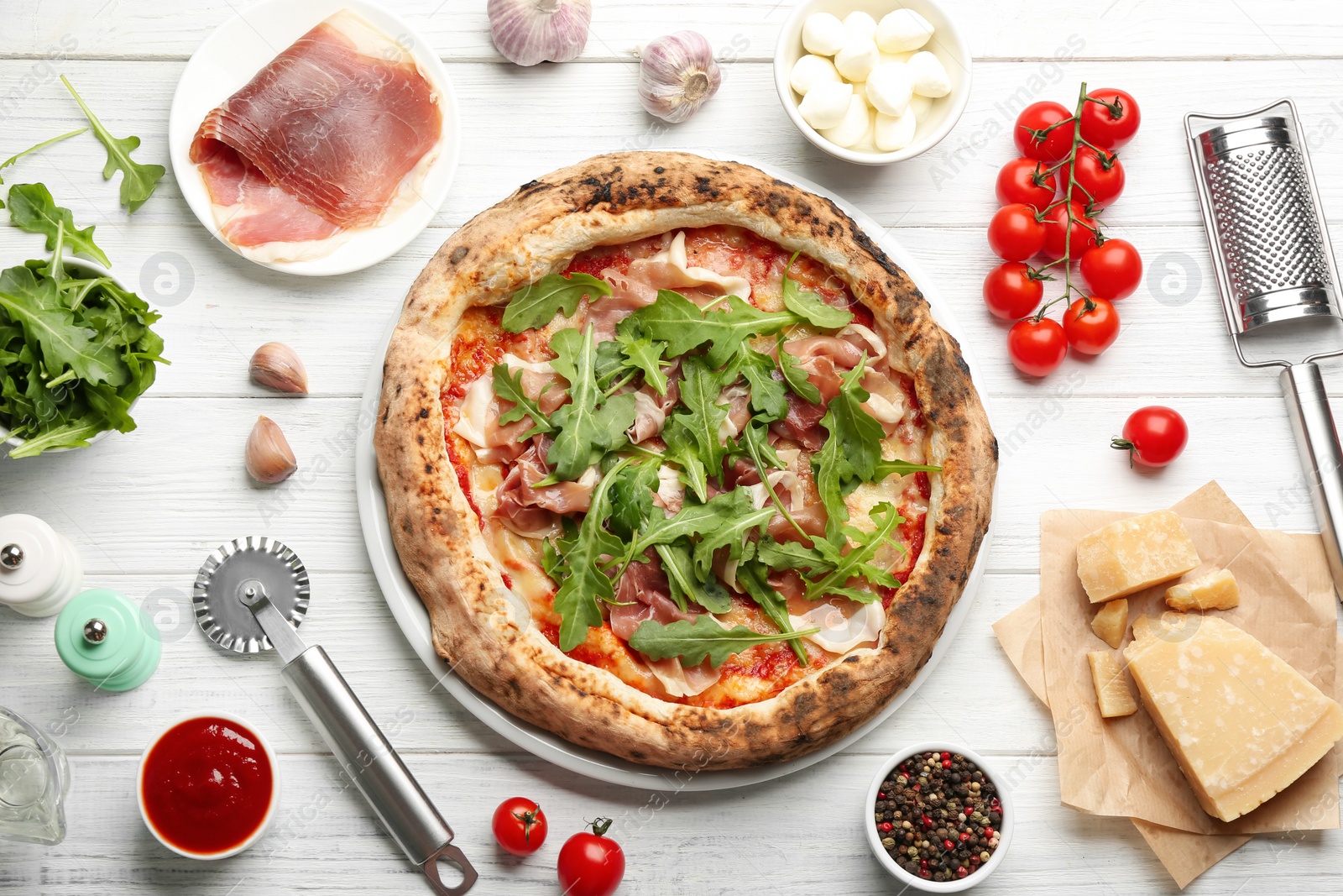 Tasty pizza with meat and arugula on white wooden table, flat lay Photo of Tasty pizza with meat and arugula on white wooden table, flat lay