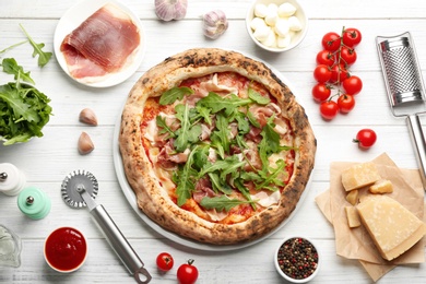Tasty pizza with meat and arugula on white wooden table, flat lay Photo of Tasty pizza with meat and arugula on white wooden table, flat lay