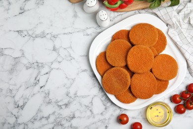 Delicious fried breaded cutlets, spices and vegetables on white marble table, flat lay. Space for text Photo of Delicious fried breaded cutlets, spices and vegetables on white marble table, flat lay. Space for text