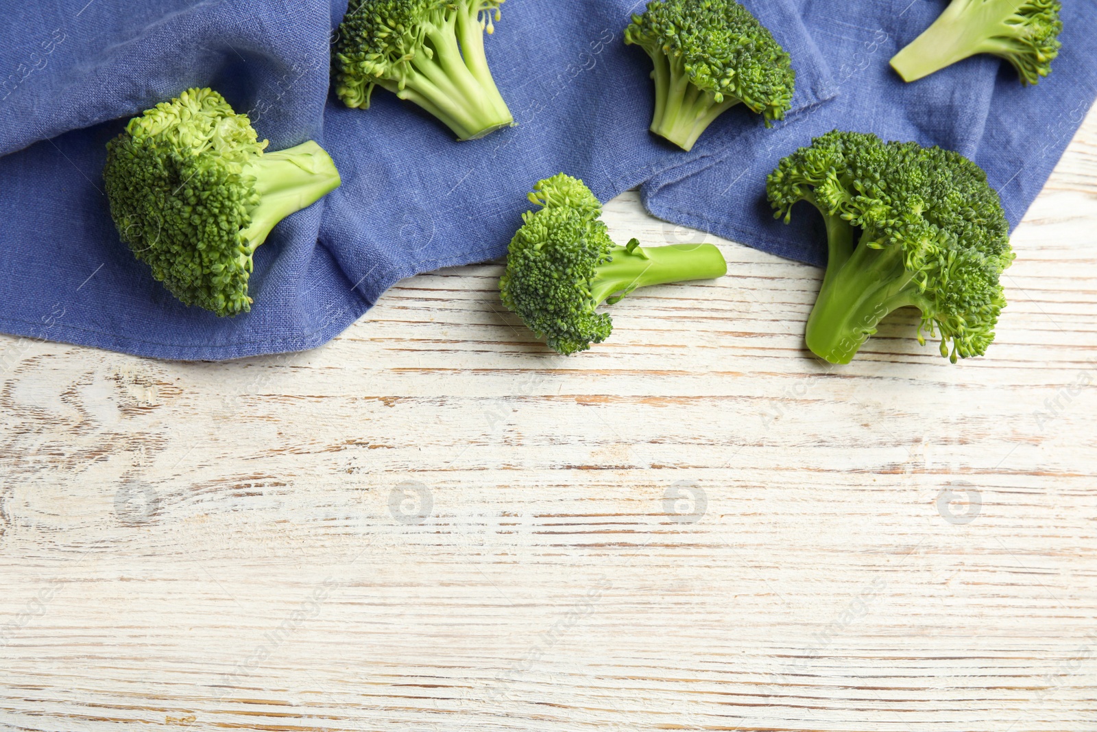 Fresh green broccoli on white wooden table, flat lay. Space for text Photo of Fresh green broccoli on white wooden table, flat lay. Space for text