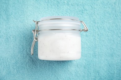 Jar of salt scrub on turquoise towel, top view Photo of Jar of salt scrub on turquoise towel, top view