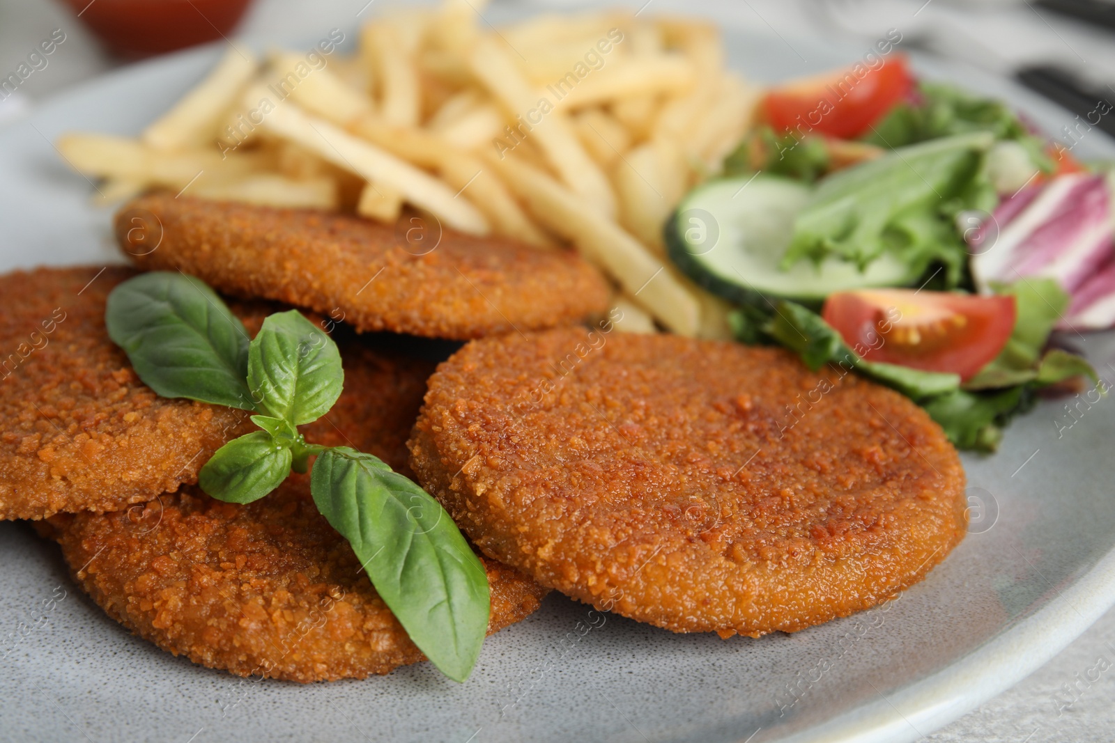 Delicious fried breaded cutlets with garnish on table, closeup Photo of Delicious fried breaded cutlets with garnish on table, closeup