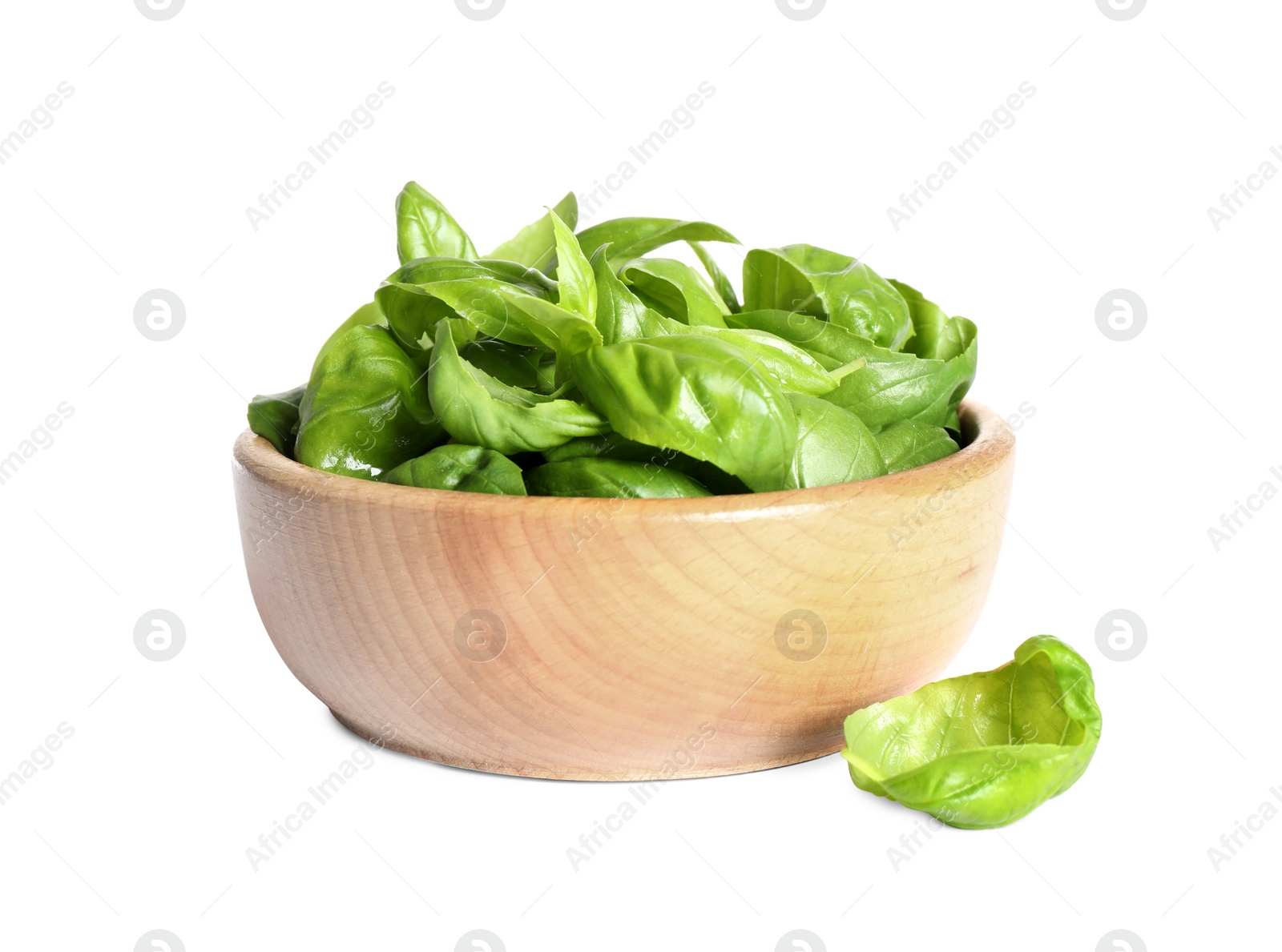 Photo of Fresh green basil leaves in wooden bowl isolated on white